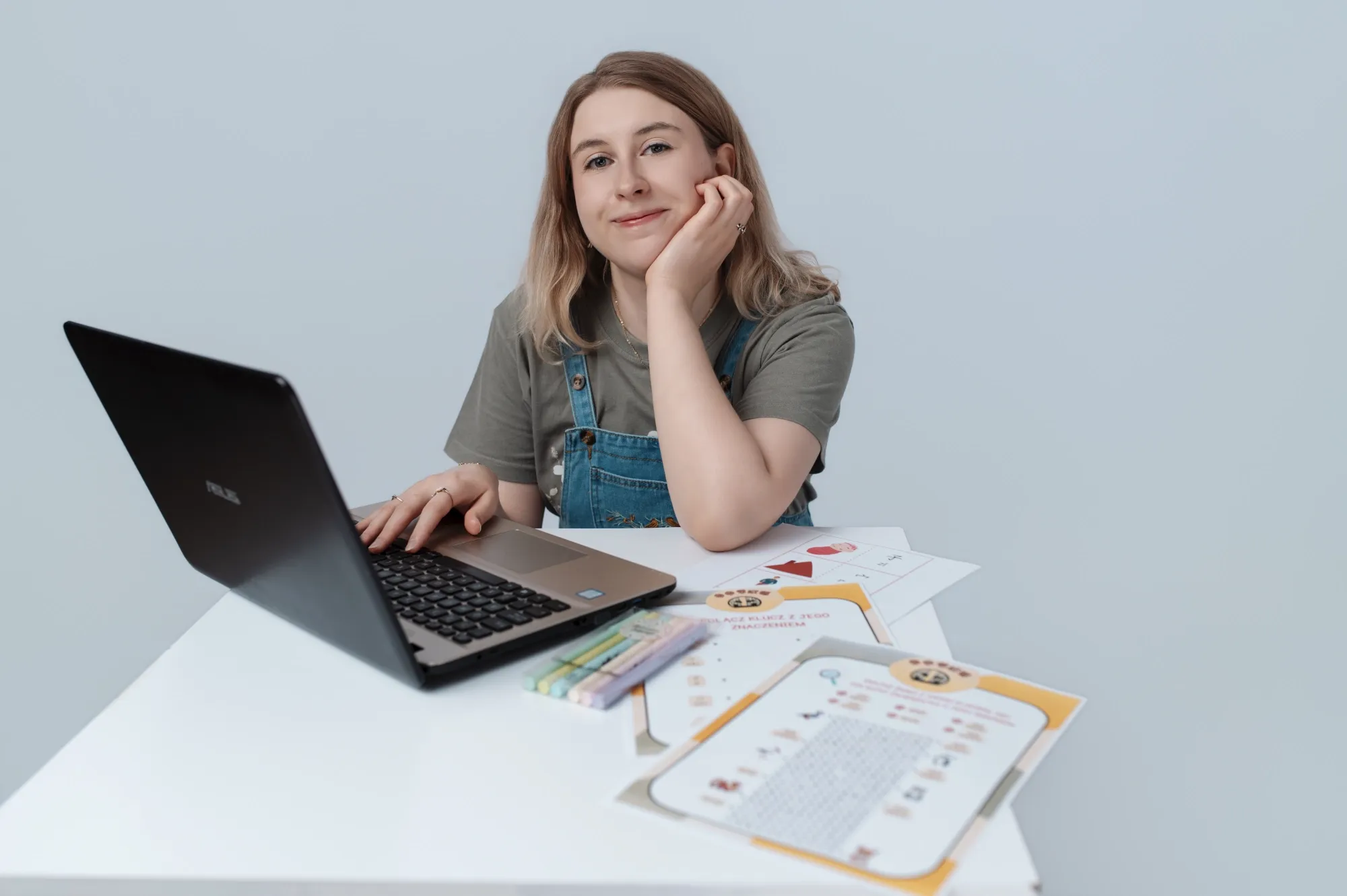 Nauczycielka chińskiego dla dzieci online siedzi przy otwartym laptopie i uśmiecha się