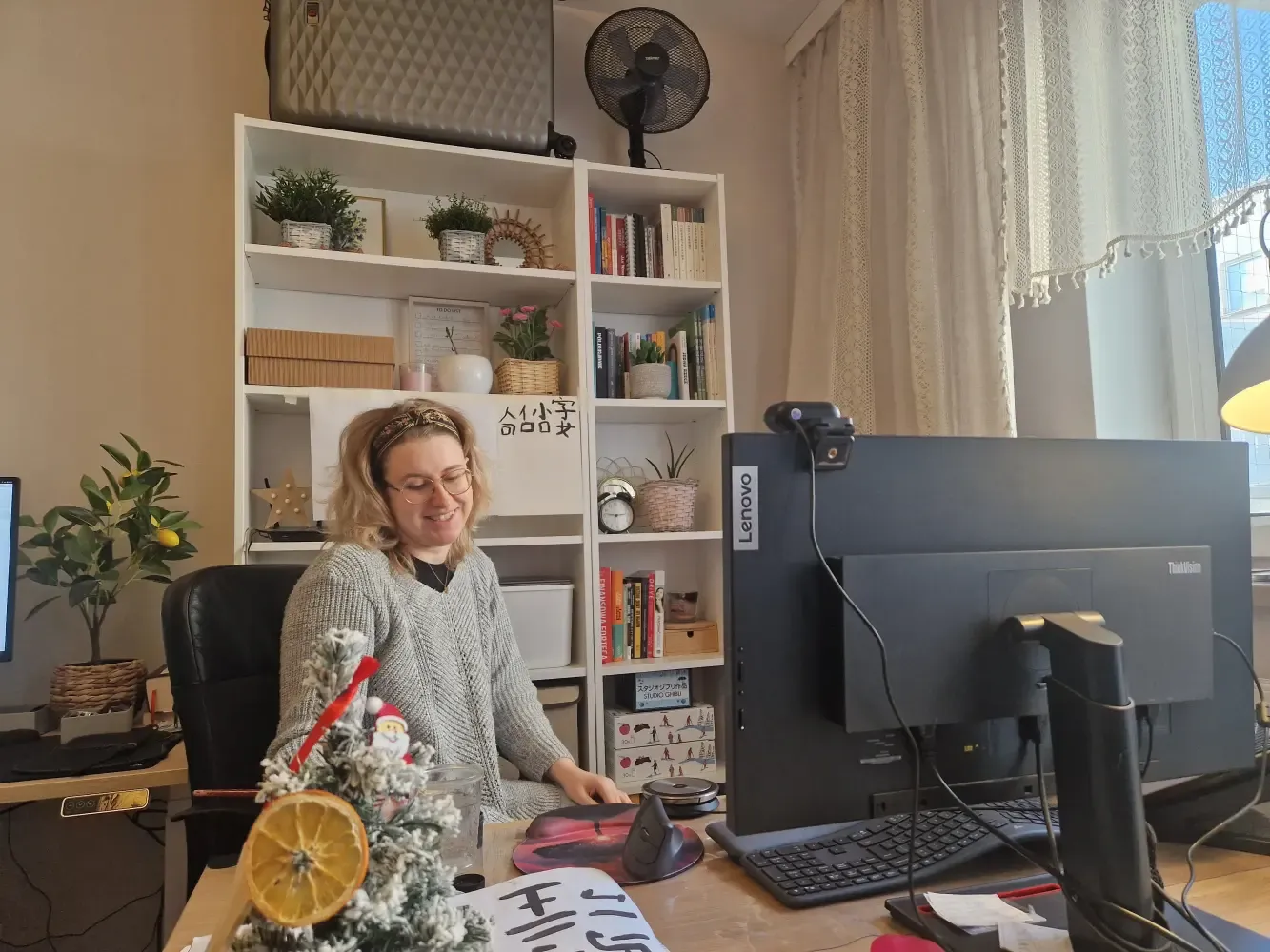 Justyna Pacześniak prowadzi zajęcia indywidualne chińskiego dla dzieci online w domowym biurze, wokół materiały z chińskimi znakami.
